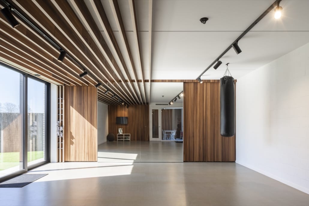 Perfecte akoestiek in de sportzaal dankzij PETAC® baffles Akoestische baffles afgewerkt met fineer voor Metis Advocaten