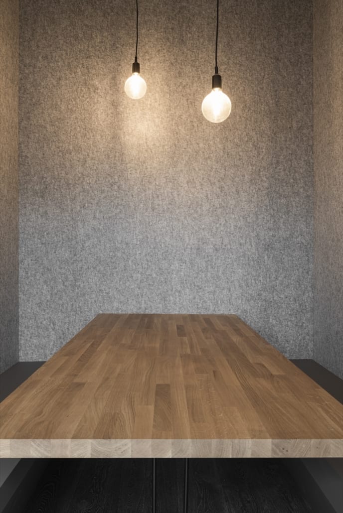 Een akoestisch comfortabele werkplek Detail akoestische wand silver met houtwerk en lampen